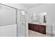 Bright bathroom featuring a glass shower and double vanity with dark wood cabinets at 7223 Sw 61St Pl, Ocala, FL 34474