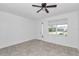 Bright bedroom with tile flooring, a ceiling fan, and a large window for natural light and fresh air at 7223 Sw 61St Pl, Ocala, FL 34474