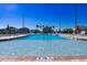 Inviting community pool features clear blue water with in-pool seating, with lounge chairs and palm trees, perfect for relaxation at 7223 Sw 61St Pl, Ocala, FL 34474