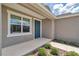 Inviting front porch with blue door, a window, and professionally landscaped garden beds on the walkway at 7223 Sw 61St Pl, Ocala, FL 34474