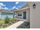 Inviting front porch and entrance with blue door, a window, and landscaped flowerbeds leading to the door at 7223 Sw 61St Pl, Ocala, FL 34474
