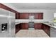 Bright kitchen has stainless appliances, dark wood cabinets, and tile floors at 7223 Sw 61St Pl, Ocala, FL 34474