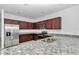 Modern kitchen features granite countertops, stainless steel appliances, and dark wood cabinets at 7223 Sw 61St Pl, Ocala, FL 34474