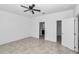 Spacious main bedroom with tile floors, ceiling fan, and multiple doorways providing flexible access at 7223 Sw 61St Pl, Ocala, FL 34474