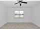 The main bedroom features bright neutral walls, a ceiling fan, and a window that allows light to enter the room at 7223 Sw 61St Pl, Ocala, FL 34474