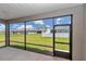 View from the screened-in patio showcasing the expansive backyard and neighboring homes at 7223 Sw 61St Pl, Ocala, FL 34474