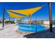 Community splash pad with colorful water features under a yellow shade, providing a fun and safe play area for children at 7223 Sw 61St Pl, Ocala, FL 34474