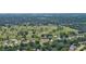 Aerial view of the house near the golf course and residential homes surrounded by green trees at 798 Fairway Dr, New Smyrna Beach, FL 32168