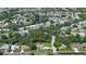 An aerial view shows the house near a small lake in a residential neighborhood filled with green trees at 798 Fairway Dr, New Smyrna Beach, FL 32168