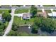 An aerial view of the house with a pond, a dock, and a beautiful landscape with lush green trees at 798 Fairway Dr, New Smyrna Beach, FL 32168