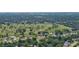 Aerial view of the house near the golf course and residential homes surrounded by green trees at 798 Fairway Dr, New Smyrna Beach, FL 32168