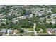 An aerial view shows the house near a small lake in a residential neighborhood filled with green trees at 798 Fairway Dr, New Smyrna Beach, FL 32168
