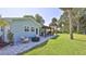 Spacious backyard featuring a stone patio, fire pit, outdoor seating, and lush green lawn at 798 Fairway Dr, New Smyrna Beach, FL 32168