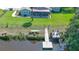 Waterfront backyard view featuring a dock, covered patio, and manicured lawn at 798 Fairway Dr, New Smyrna Beach, FL 32168