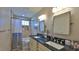 Well-lit bathroom features a double vanity with dark countertop and tiled shower with updated fixtures at 798 Fairway Dr, New Smyrna Beach, FL 32168