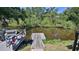 Wooden dock on the waterfront, offering a serene view of the tranquil water and lush greenery at 798 Fairway Dr, New Smyrna Beach, FL 32168