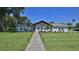 Charming home with a beautifully landscaped front yard, brick pathway, and inviting curb appeal at 798 Fairway Dr, New Smyrna Beach, FL 32168