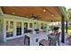 Outdoor kitchen area with a grill, dining bar and overhead fans on a brick patio at 798 Fairway Dr, New Smyrna Beach, FL 32168