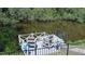 Tranquil waterfront view featuring a well-maintained dock with relaxing chair accommodations at 798 Fairway Dr, New Smyrna Beach, FL 32168