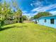 Large green backyard, framed by a wooden fence and lush trees at 903 Conrad Dr, New Smyrna Beach, FL 32168