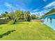 A large, well-maintained backyard featuring a lawn, wooden fence, mature trees and shrubs at 903 Conrad Dr, New Smyrna Beach, FL 32168