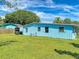 Spacious backyard with lush green grass and a bright blue home at 903 Conrad Dr, New Smyrna Beach, FL 32168