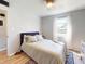 Bright bedroom features a bed, ceiling fan, window, and light wood flooring at 903 Conrad Dr, New Smyrna Beach, FL 32168