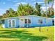 Inviting light blue home showcasing a well-manicured lawn and attractive curb appeal at 903 Conrad Dr, New Smyrna Beach, FL 32168