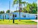 Charming blue single-story home with a well-maintained lawn and mature landscaping featuring a palm tree in the front yard at 903 Conrad Dr, New Smyrna Beach, FL 32168