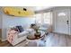 Bright living room featuring a surfboard accent, comfortable couch, bright windows, and light wood floors at 903 Conrad Dr, New Smyrna Beach, FL 32168