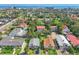 An aerial view of a neighborhood showcasing vibrant, lush landscaping, blue skies, and a distant ocean view at 934 N Halifax Ave, Daytona Beach, FL 32118