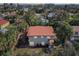 A birds eye view of a home featuring a distinctive red roof surrounded by verdant trees and tropical foliage at 934 N Halifax Ave, Daytona Beach, FL 32118
