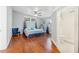 This spacious bedroom features hardwood floors, a ceiling fan, and an ensuite bathroom with white tiling at 934 N Halifax Ave, Daytona Beach, FL 32118