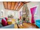 Cozy living room featuring wood-beamed ceilings, hardwood floors and an impressive stone fireplace at 934 N Halifax Ave, Daytona Beach, FL 32118