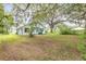 Home exterior view showcasing the spacious backyard at 102 N Brooks Cir, Oak Hill, FL 32759