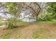 Backyard featuring mature trees and detached garage at 102 N Brooks Cir, Oak Hill, FL 32759