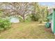 Spacious backyard with mature trees and a detached garage at 102 N Brooks Cir, Oak Hill, FL 32759