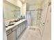 Bathroom featuring double sinks, gray cabinets, tiled floors and a glass enclosed shower at 103 Old Mill Pond Rd, Edgewater, FL 32141