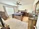 Bright bedroom with a wooden bed frame, dresser, nightstands, and carpet flooring at 103 Old Mill Pond Rd, Edgewater, FL 32141