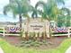 Inviting entrance to Woodbridge Lakes featuring decorative landscaping, flowers, and patriotic bunting at 103 Old Mill Pond Rd, Edgewater, FL 32141