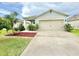 Inviting single-story home with a well-kept yard, a large driveway, and an attached garage at 103 Old Mill Pond Rd, Edgewater, FL 32141