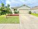 Lovely single-story home with a spacious driveway, manicured lawn, and attached two-car garage at 103 Old Mill Pond Rd, Edgewater, FL 32141