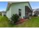View of the back exterior, with Florida landscaping and a screened-in lanai at 1221 Siesta Key Cir, Port Orange, FL 32128