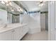 Large bathroom featuring double sinks, bathtub, glass block window, and decorative wallpaper trim at 1221 Siesta Key Cir, Port Orange, FL 32128