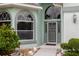 Close up of front door with decorative glass and arched windows, lush landscaping at 1221 Siesta Key Cir, Port Orange, FL 32128