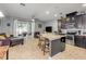 Open-concept kitchen with dark cabinets, granite countertops, and island with seating overlooking living room at 1453 River Rock Ct, Oviedo, FL 32765