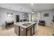 Open concept living space with a kitchen island, dining area, and sliding doors to the outdoor patio at 1453 River Rock Ct, Oviedo, FL 32765