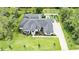 An aerial view of a custom home with lush landscaping and features including pool and play area at 1616 Turnbull Crossings Dr, New Smyrna Beach, FL 32168