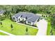 An aerial view of a stunning two-story home with lush landscaping and a winding stone driveway at 1616 Turnbull Crossings Dr, New Smyrna Beach, FL 32168