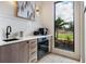 Stylish bar area with modern appliances, under cabinet lighting, and a view of the yard at 1616 Turnbull Crossings Dr, New Smyrna Beach, FL 32168